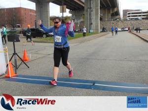 Lisa crossing finish line of a 5K foot race